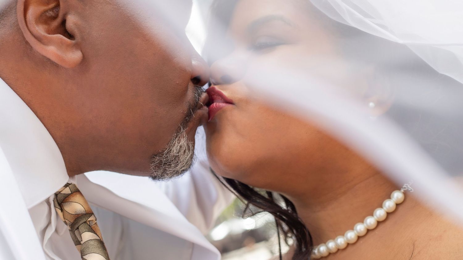 Photo of a wedding couple embracing a kiss.