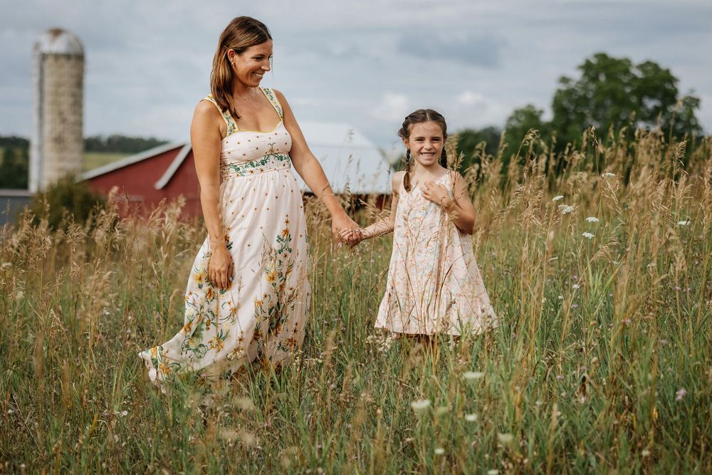 A joyful gathering in a wildflower meadow with light summer dresses and natural scenery.