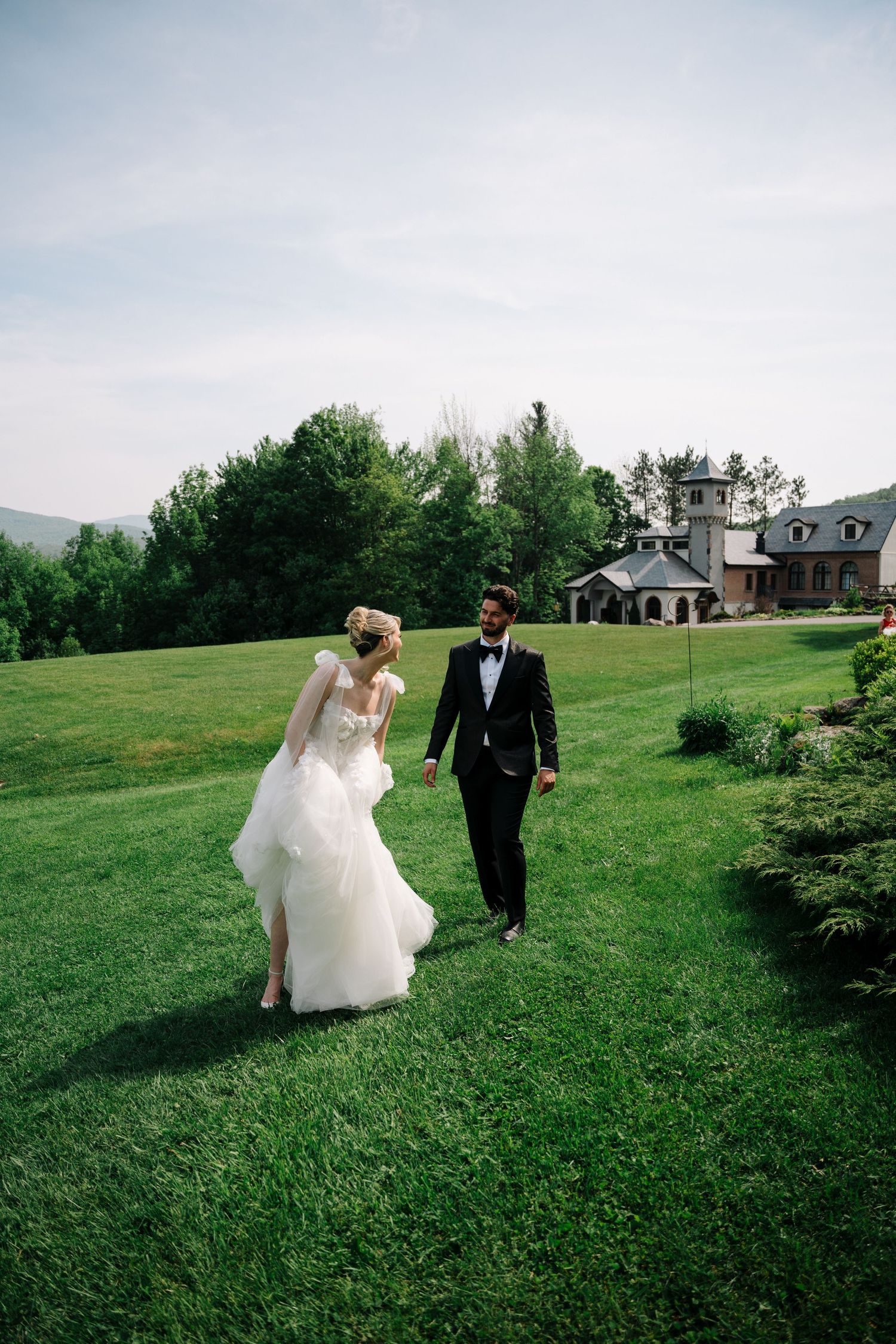 Elegant wedding scene with couple standing by candlelit fireplace surrounded by floral arrangements.
