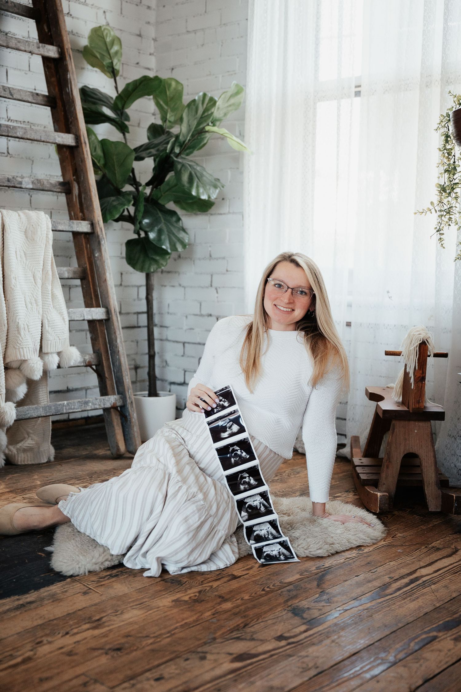 A romantic indoor photoshoot with a crystal chandelier and leather couch in a rustic setting.