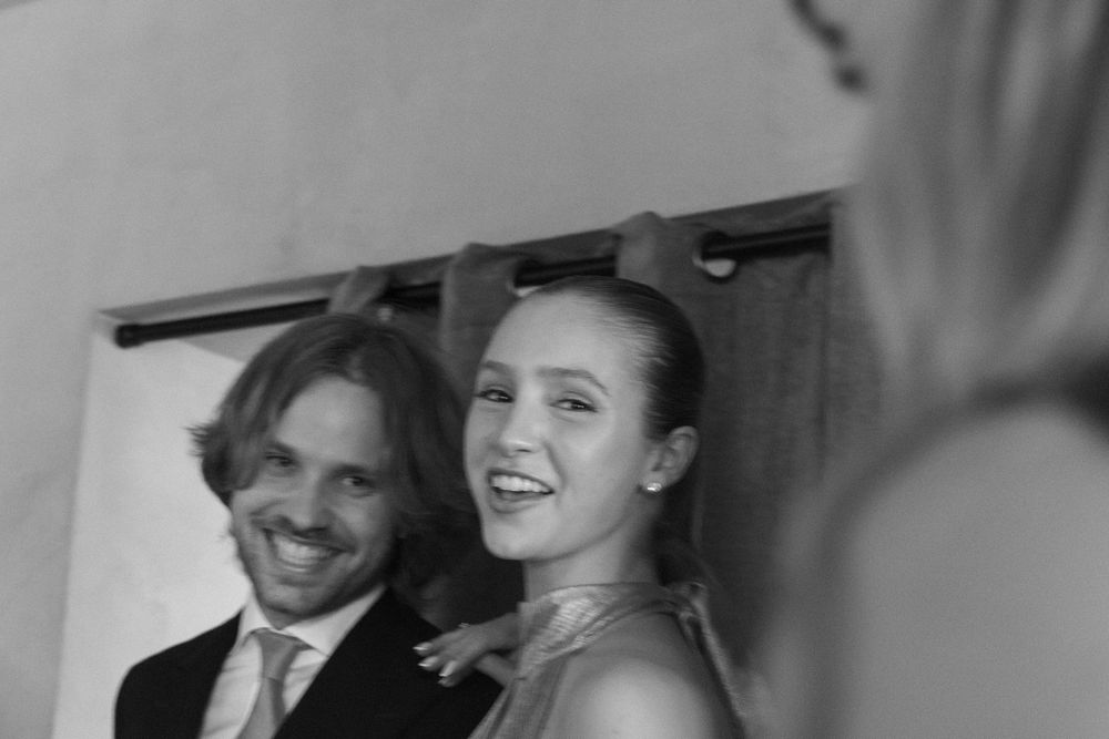Black and white photo of a smiling couple at a formal event, woman in elegant dress, man in suit with tie.