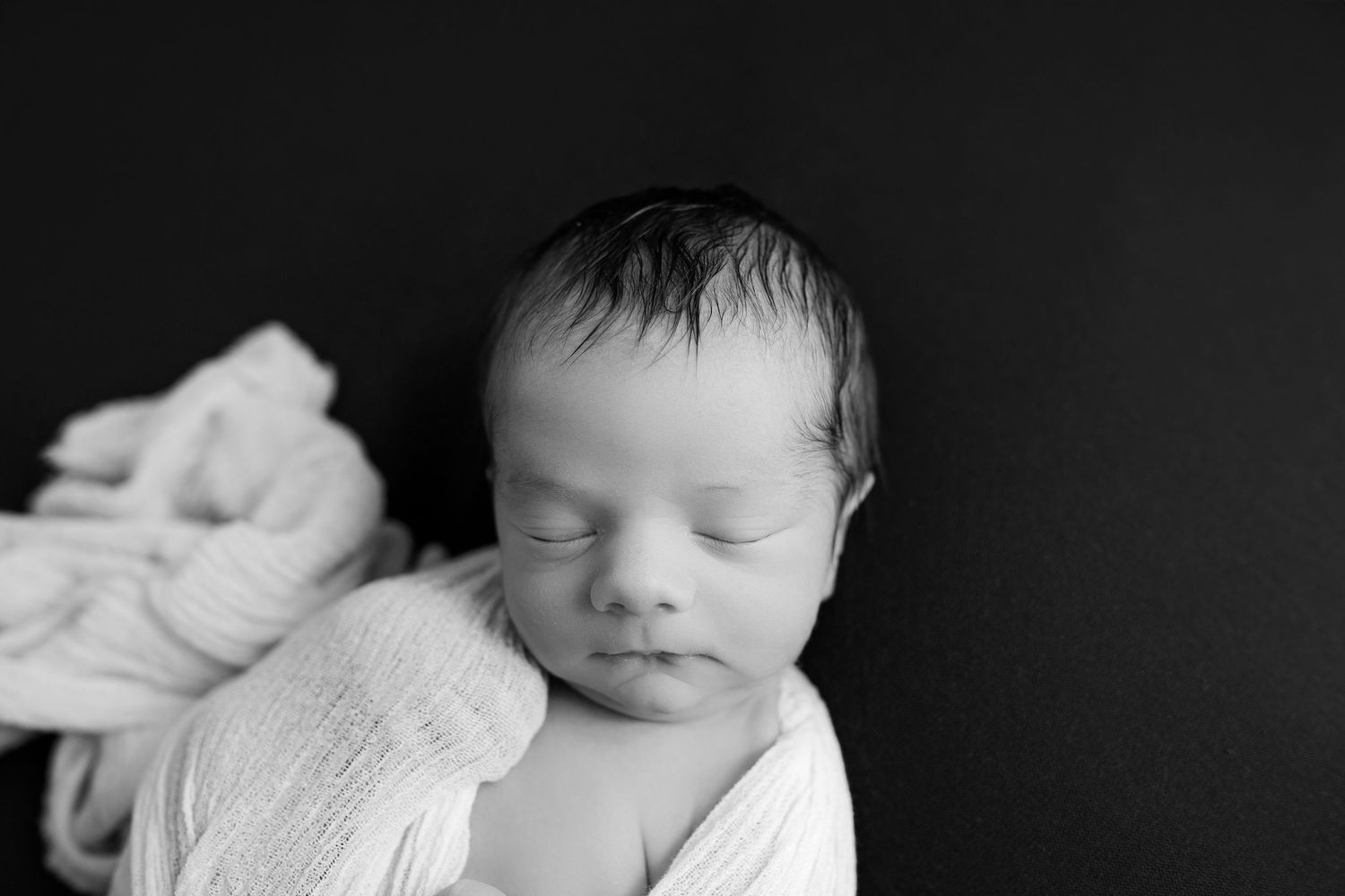 Black and white portrait of sleeping newborn wrapped in soft white fabric.maternity, and family photography galleries from New Braunfels,tex