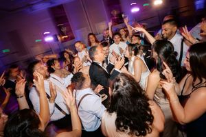 Guests dancing and celebrating at a lively wedding reception party on the dance floor.