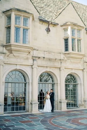 Elegant stone building exterior with arched windows and bay windows features classic European architectural details.