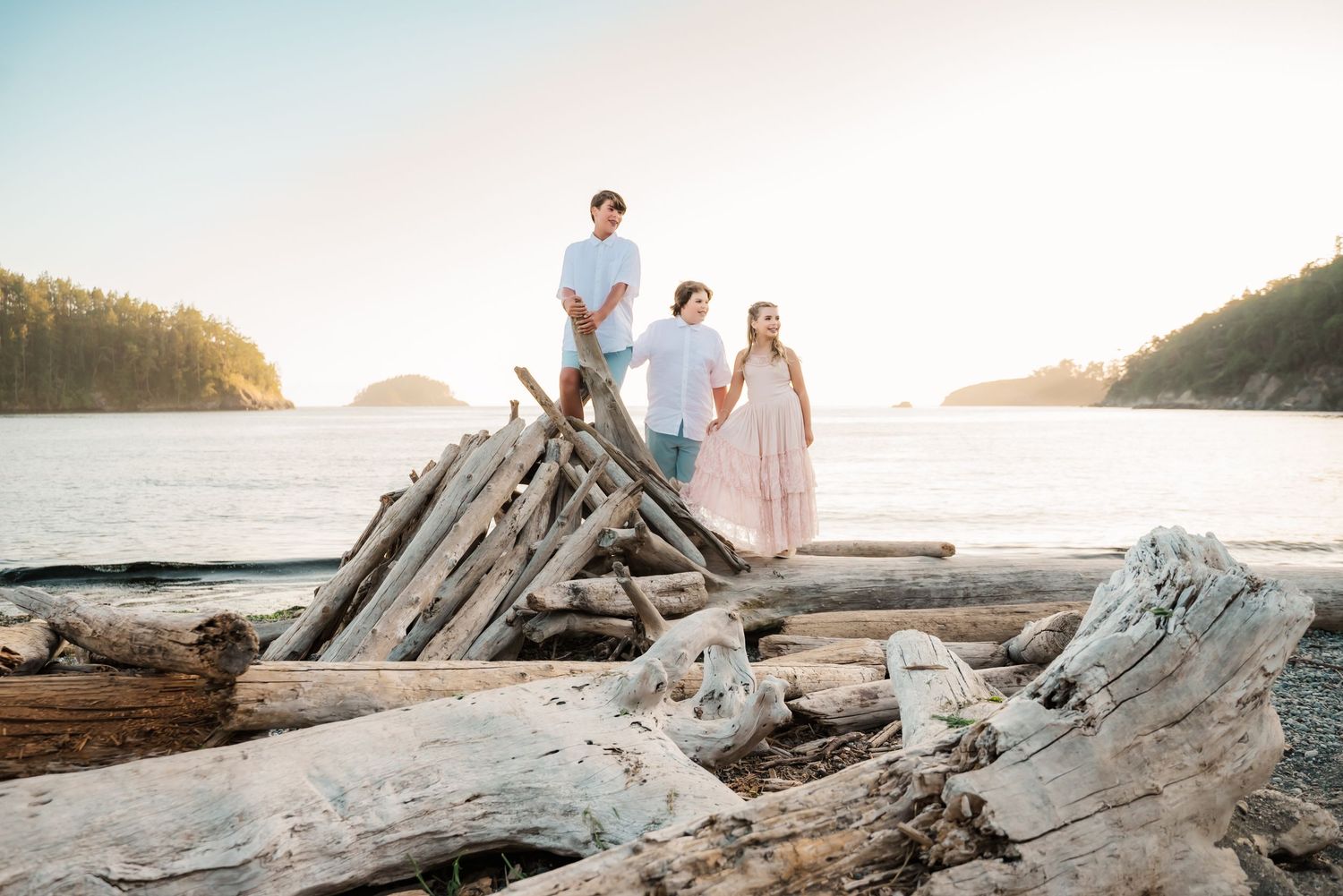 siblings play on driftwood at Deception Pass State Park, Bowman Bay