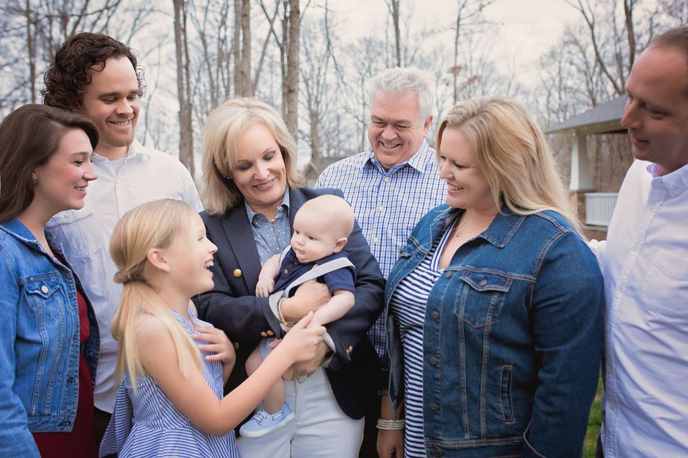 Extended family gathering outdoors sharing special moments with a baby.
family photography