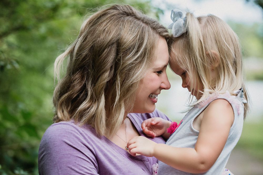 Intimate moment of joy and laughter captured between parent and child outdoors.
family photography