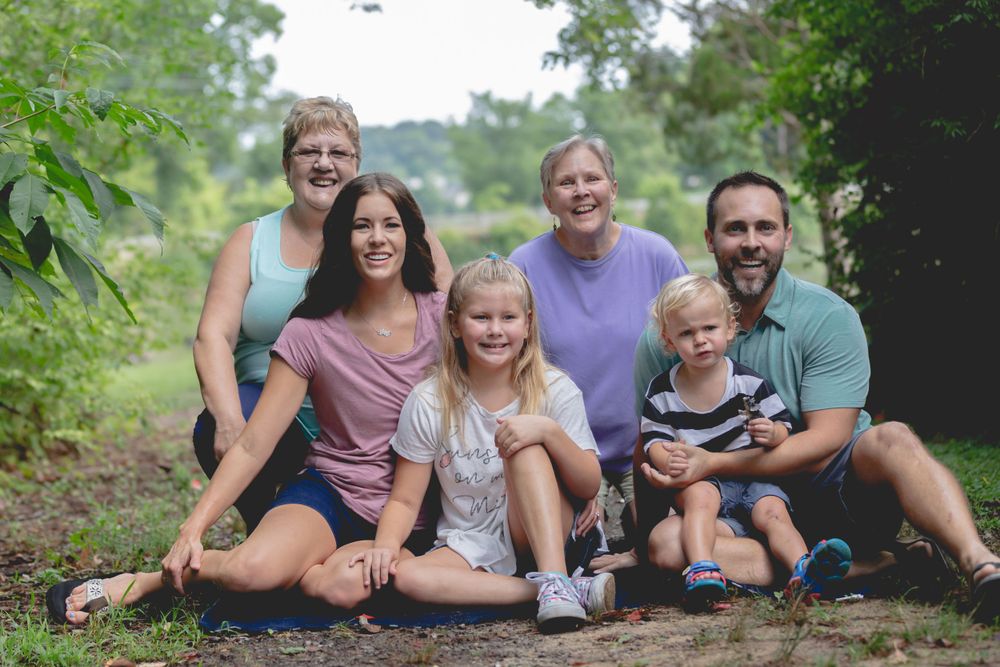Casual outdoor family portrait session in a natural wooded setting.