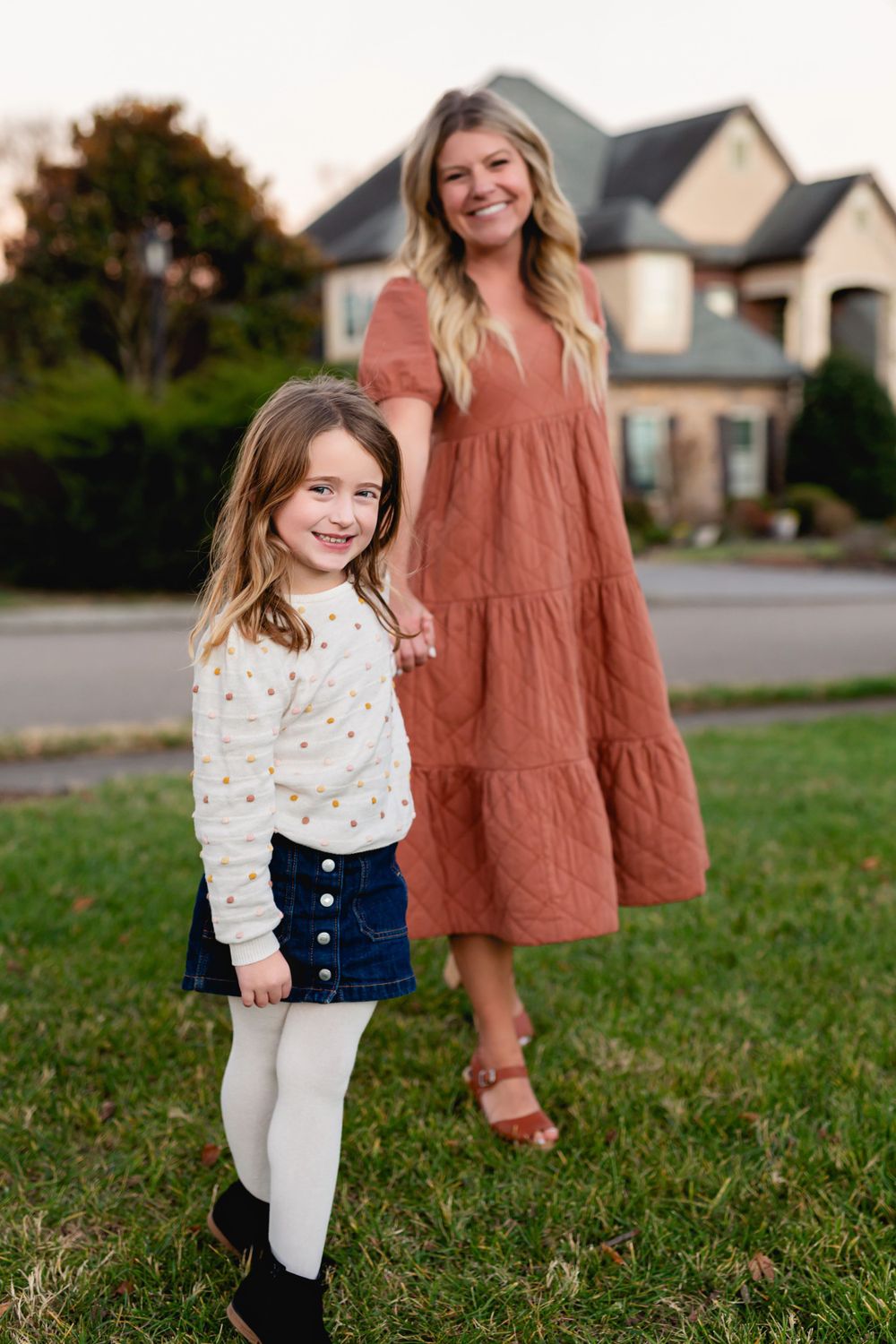 Standing portrait outdoors with rustic house in background during golden hour.
family photography