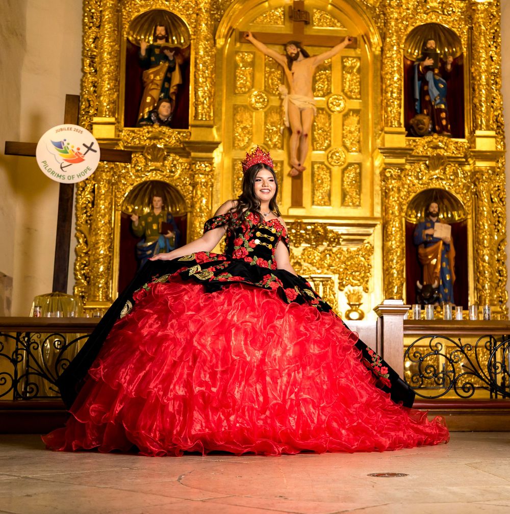 Red and black ball gowns with full skirts arranged in a row inside an ornate golden church interior.