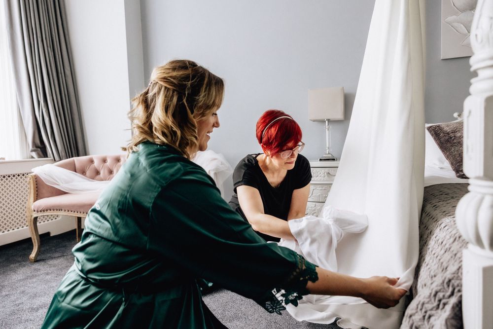 bridesmaids steaming wedding dress