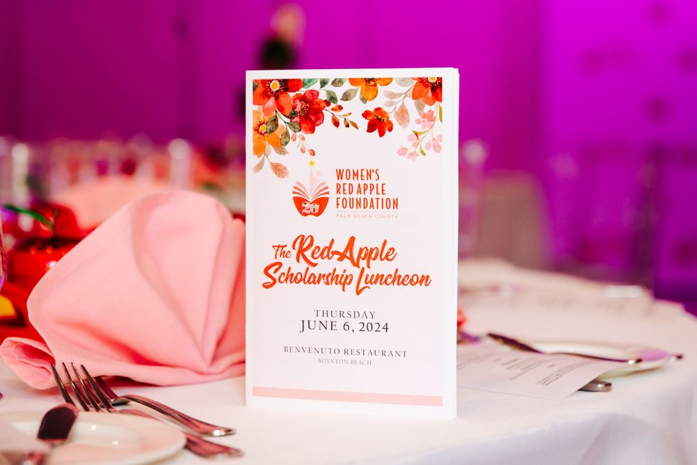 Pink-tinted event space featuring elegant place settings and decorative name cards.