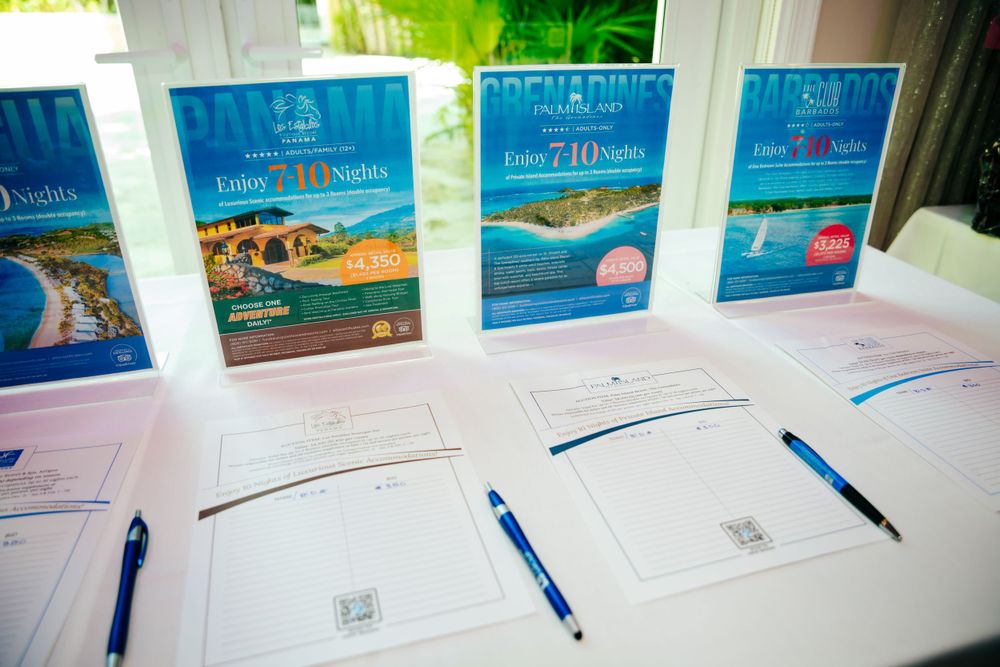 Travel brochures and documents arranged on a table with blue pens.
