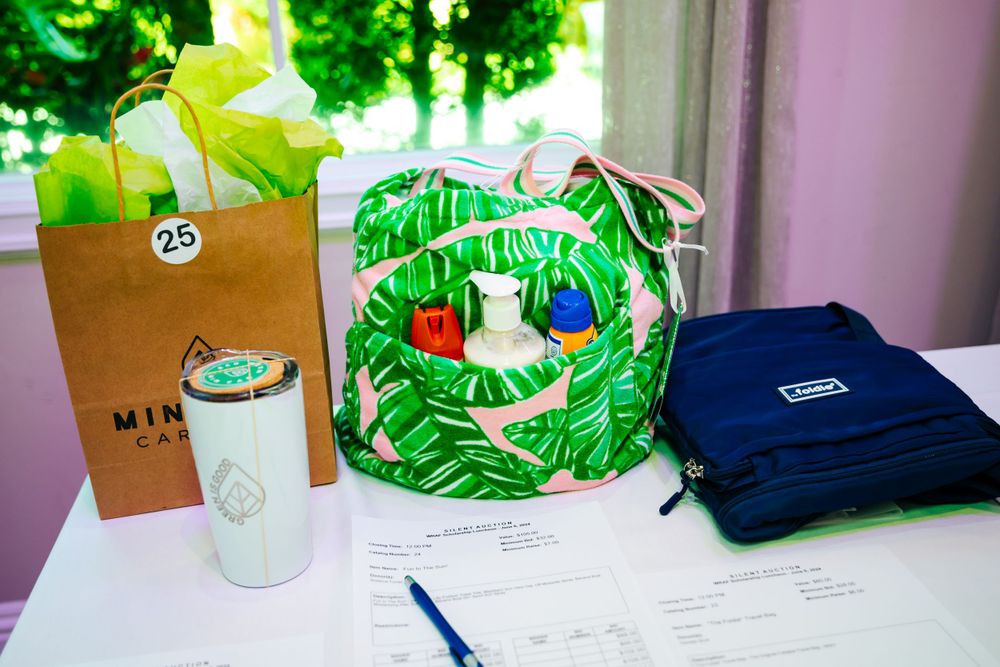 Green gift bag and tropical themed bag with beverages on a table.