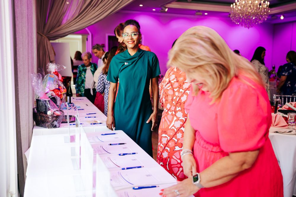 Elegant event space decorated with crystal chandeliers and dramatic purple uplighting.