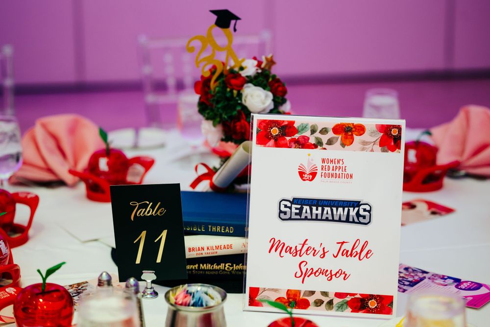 Name cards and table numbers displayed alongside floral arrangements at a formal event.