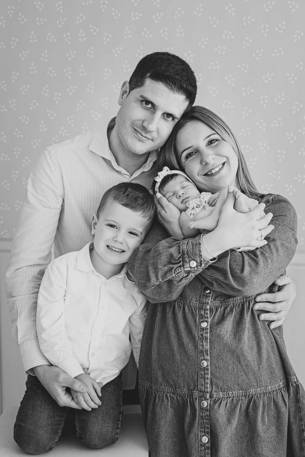Fotografía de familia de recién nacido dormida en una dulce pose en brazos de mamá, capturada en su sesión de fotos.
