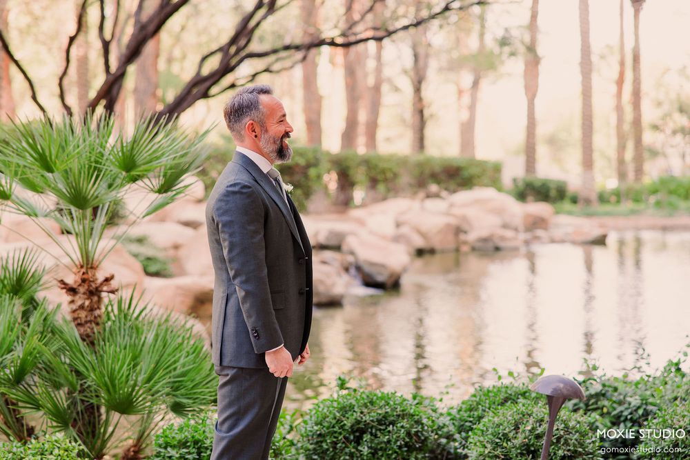 Couple walking hand in hand through a scenic garden path with blooming flowers and natural landscaping.
