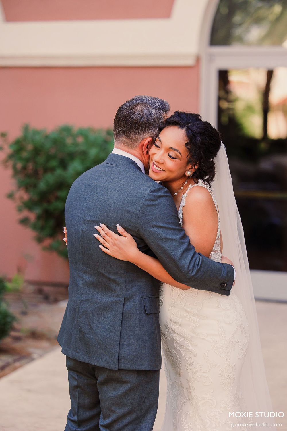 A romantic wedding photo series showing tender embraces between a couple against a pink wall.