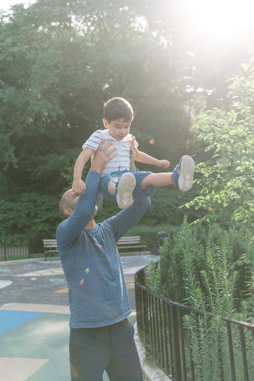 Sequence of shots showing a child in blue doing a fun playful gymnastics flip move in a sunny outdoor setting.