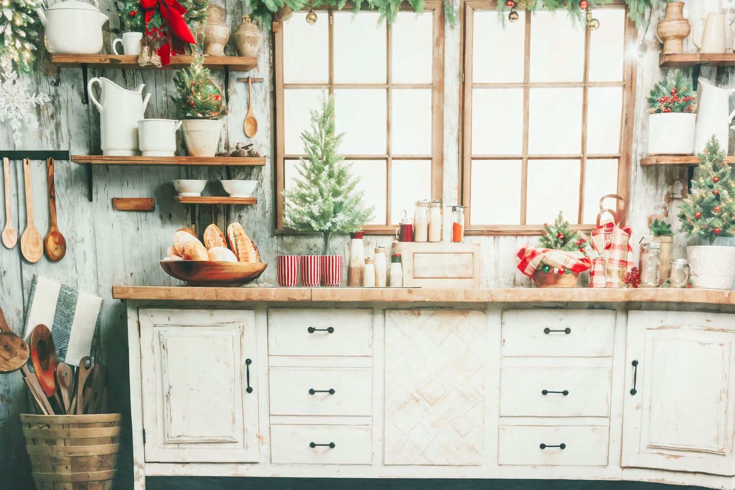 Rustic white kitchen decorated for Christmas with greenery and festive accents.