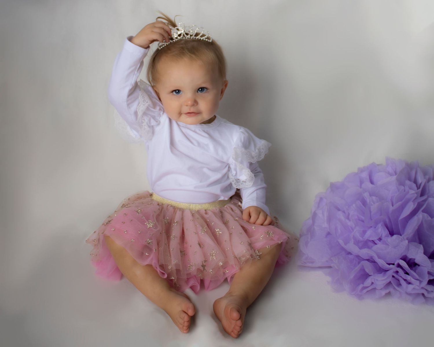 A toddler girl plays with her hair