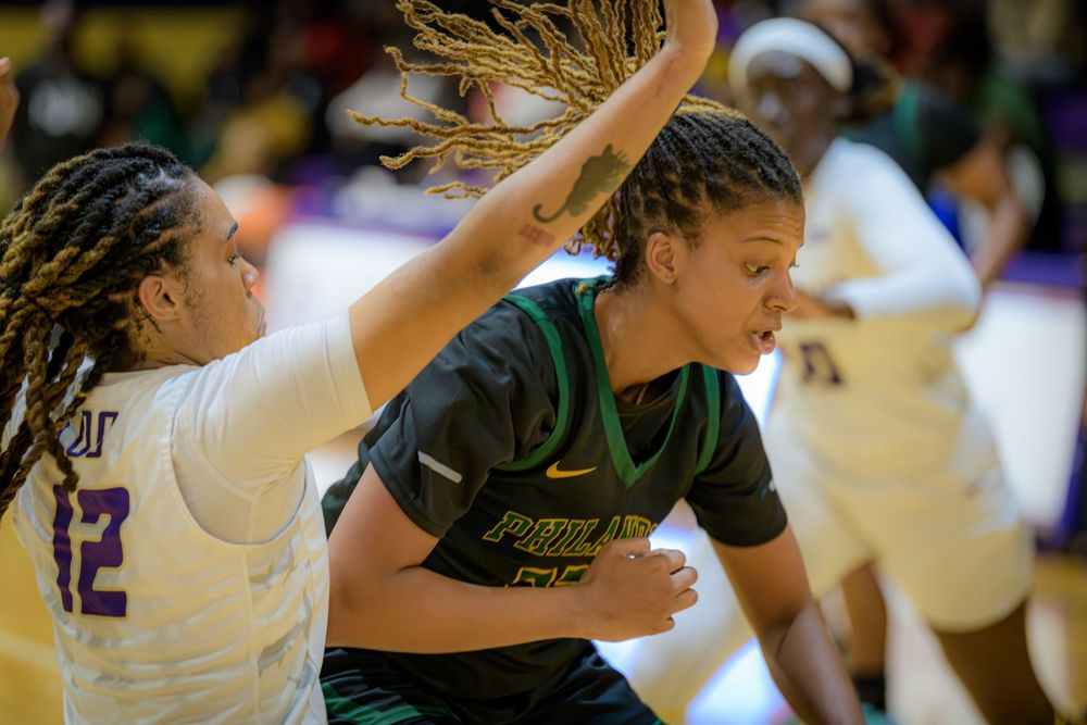 Basketball players from opposing teams battle for possession of the ball during an intense game.