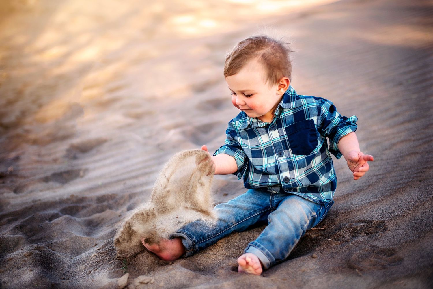 young boy plays with a hand full of sand family photography Ellensburg, WA