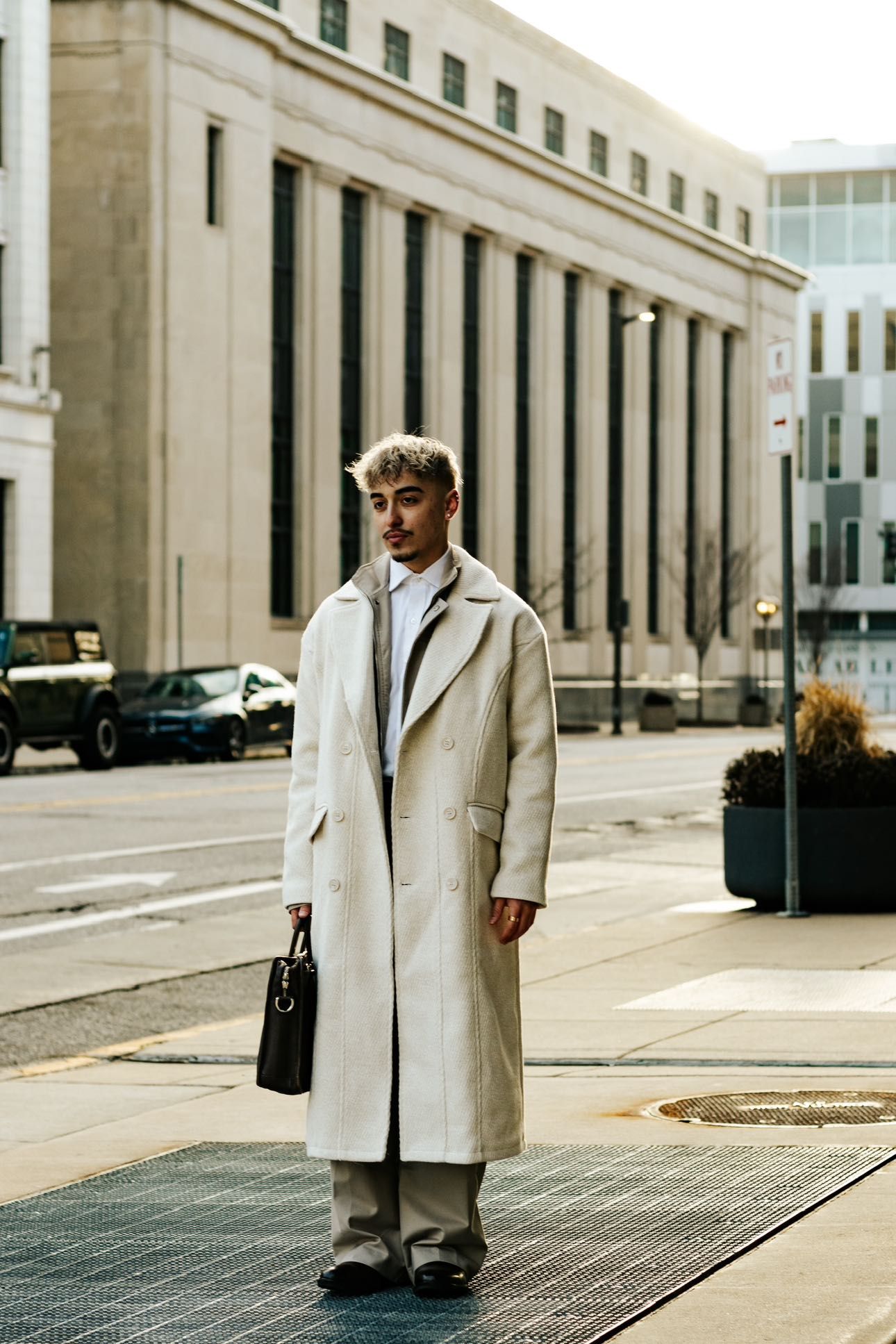Person in beige coat photographed from different angles against urban architecture.