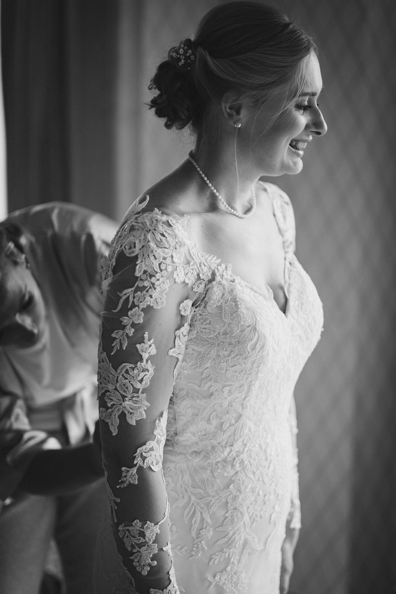 Intricate lace details of a wedding dress captured in classic black and white photography.