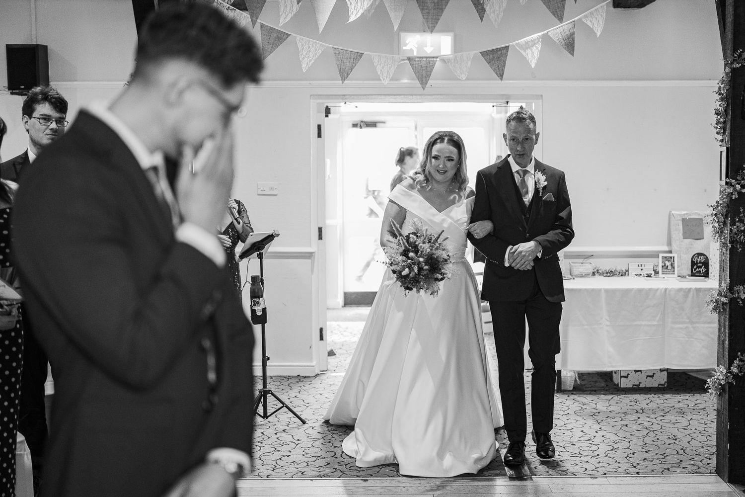 Wedding ceremony captured in an intimate indoor venue with classic decor and lighting.