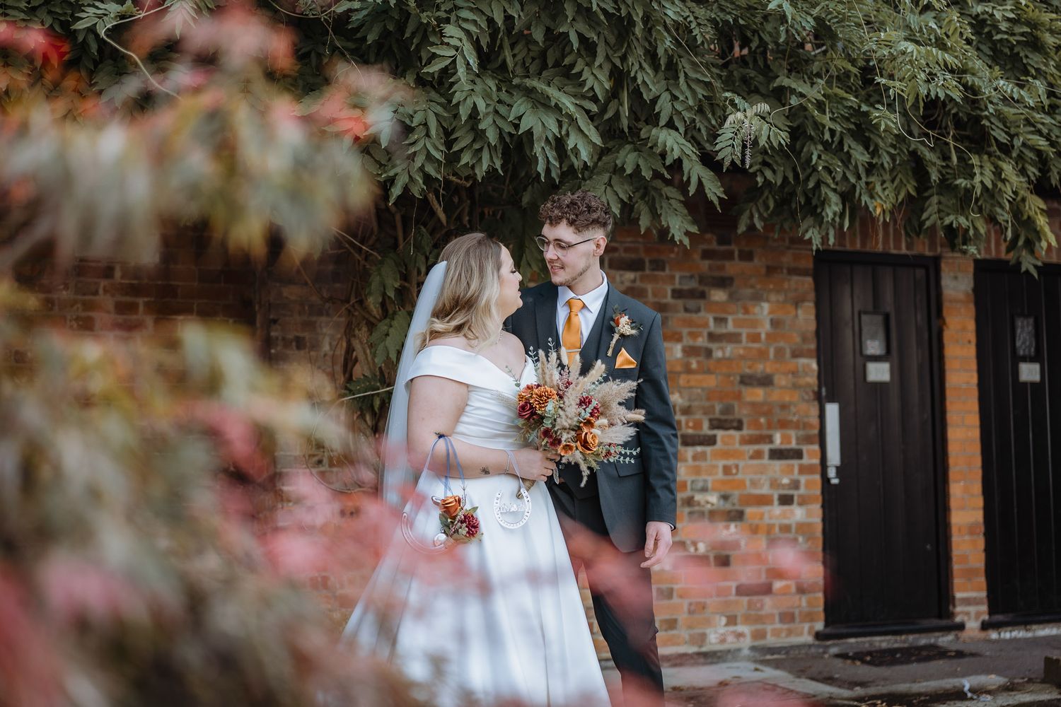 Wedding ceremony setup with brick walls and greenery creating a romantic atmosphere.