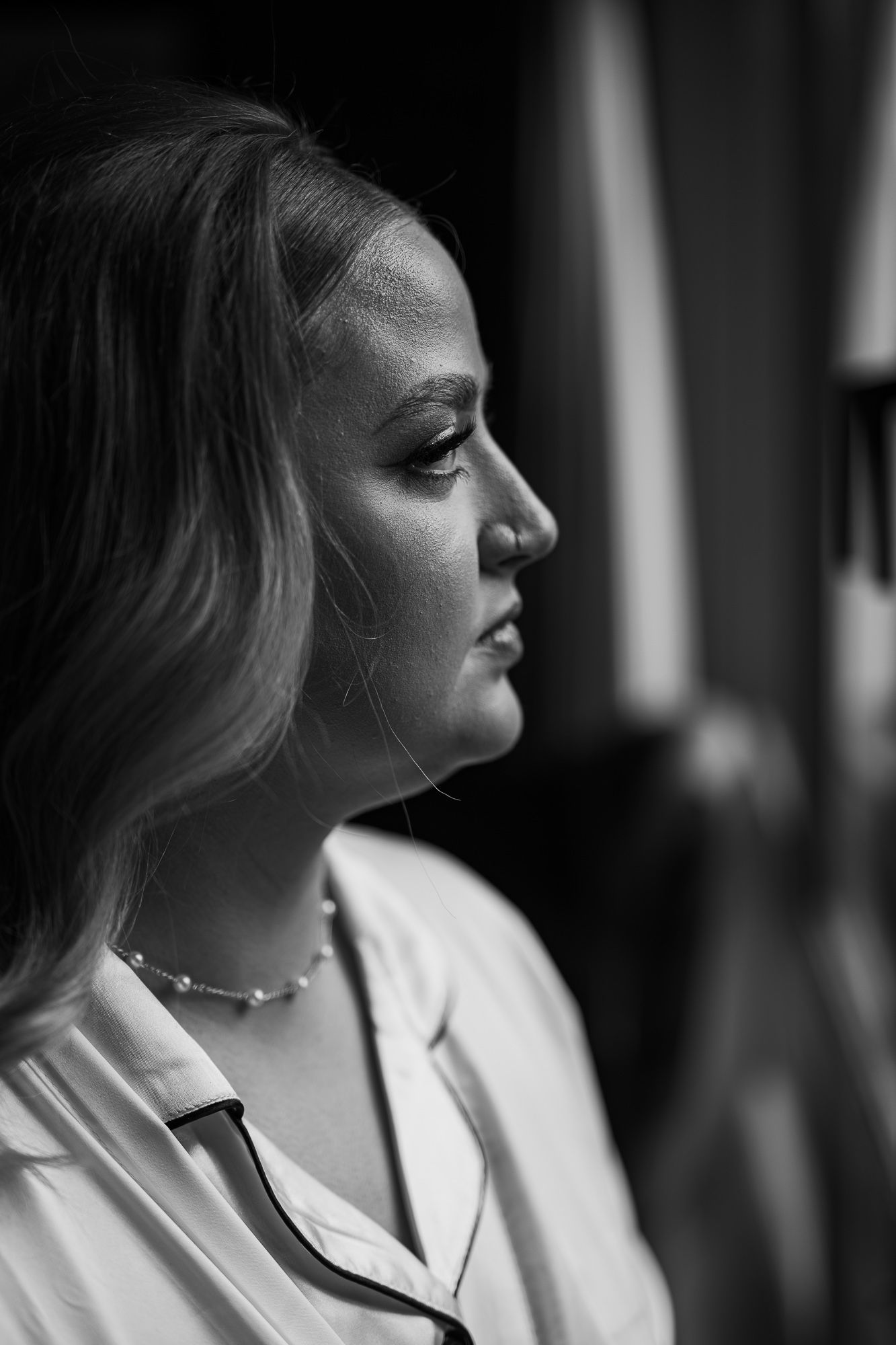 Dramatic black and white profile portrait showcasing elegant wedding day styling.