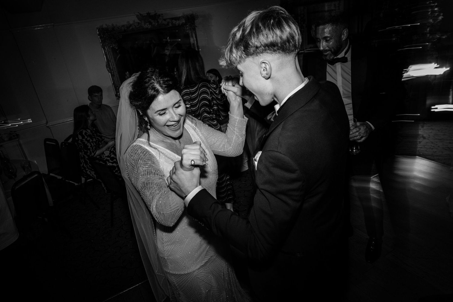 A couple shares a joyful dance moment at their wedding reception.