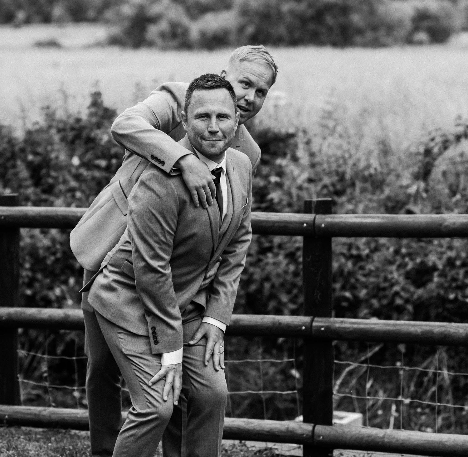 Candid black and white shots of playful moments along a wooden fence.