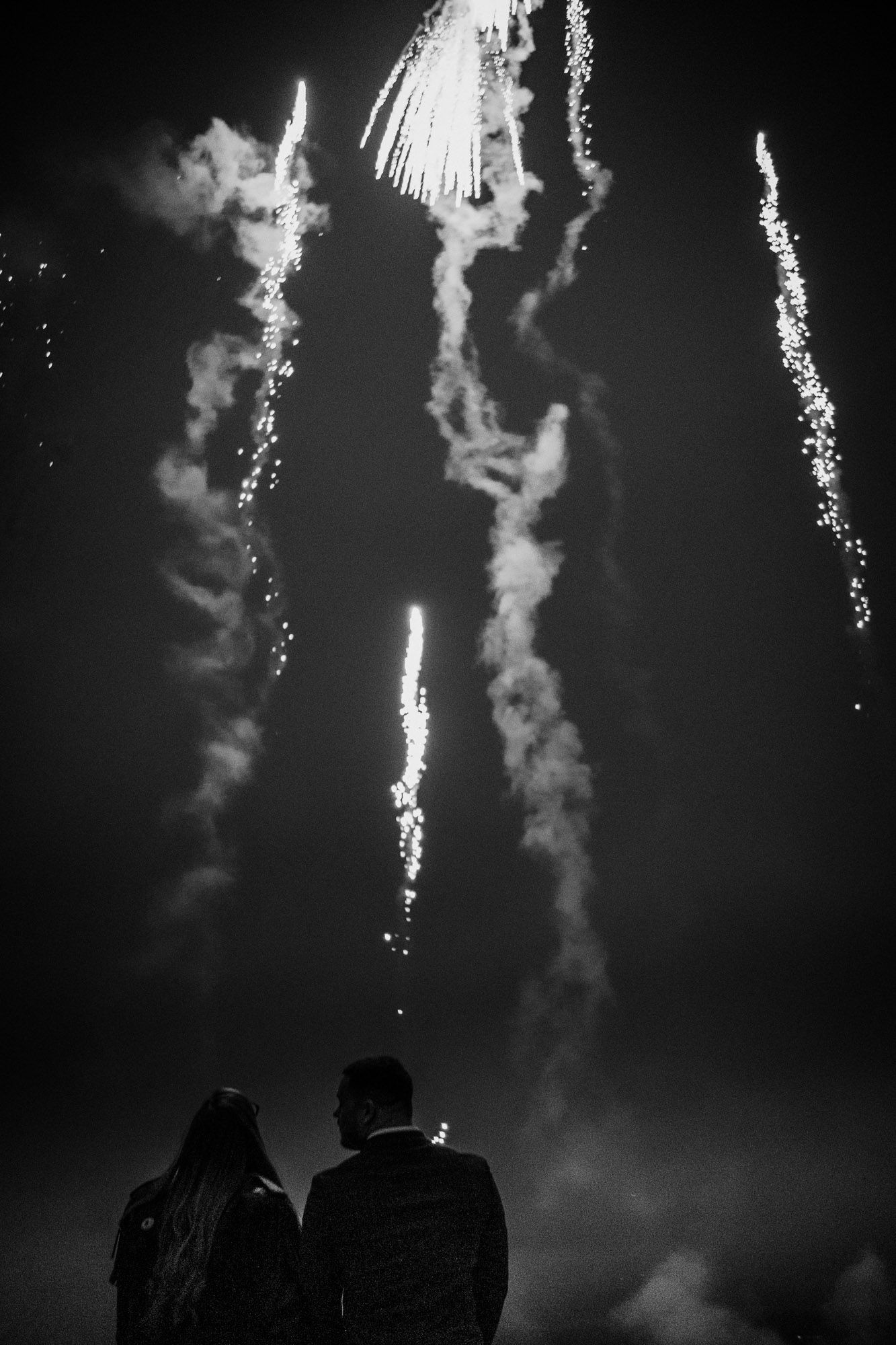 Spectacular fireworks display lighting up the night sky in black and white.