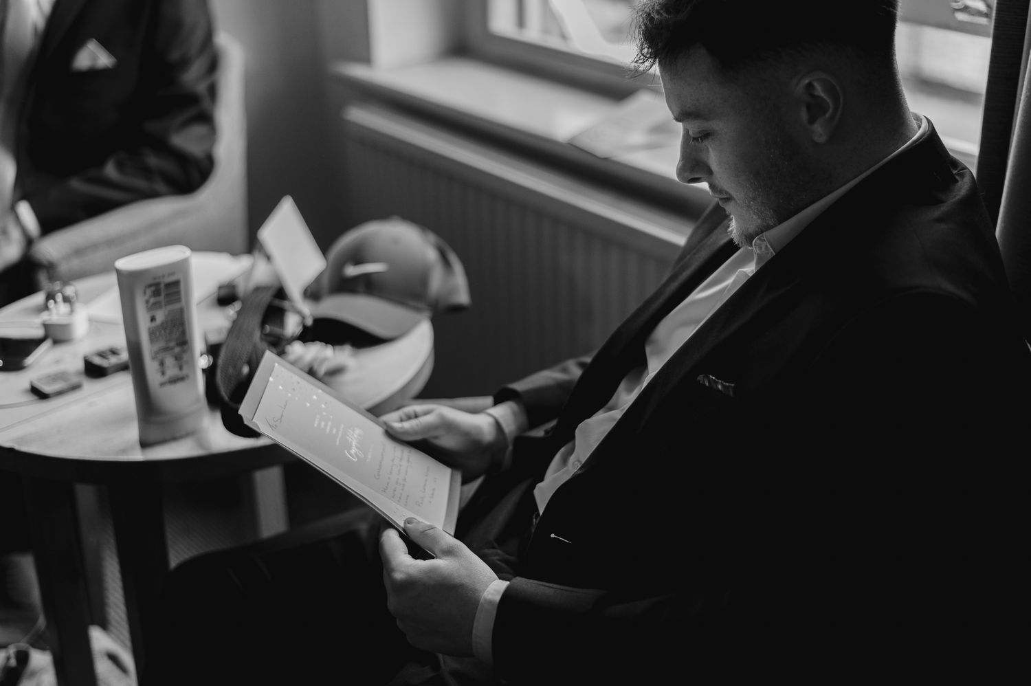 Black and white photo of wedding guests seated in formal attire during a ceremony.