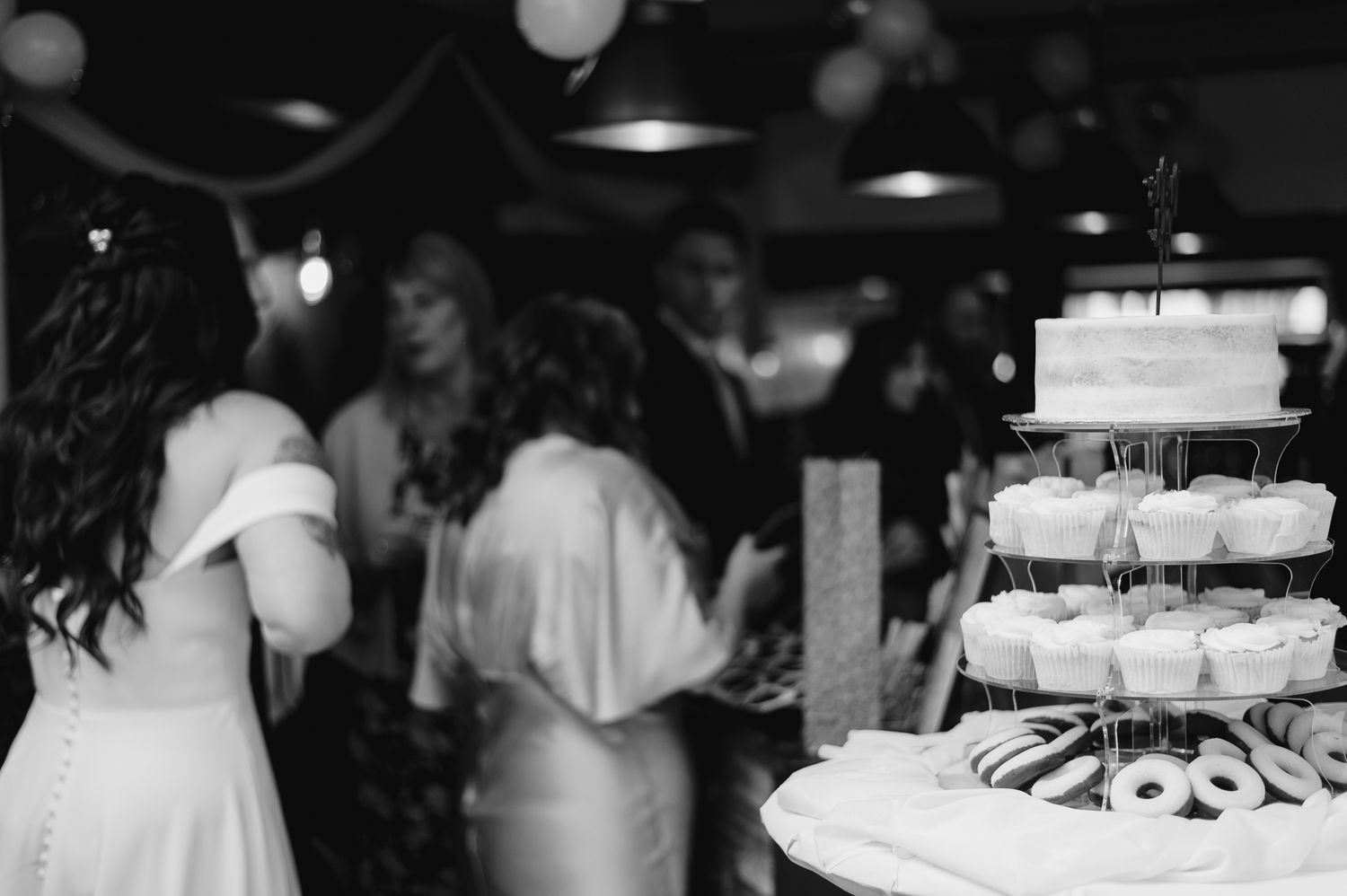 Wedding dessert table with cupcakes and treats displayed at reception.