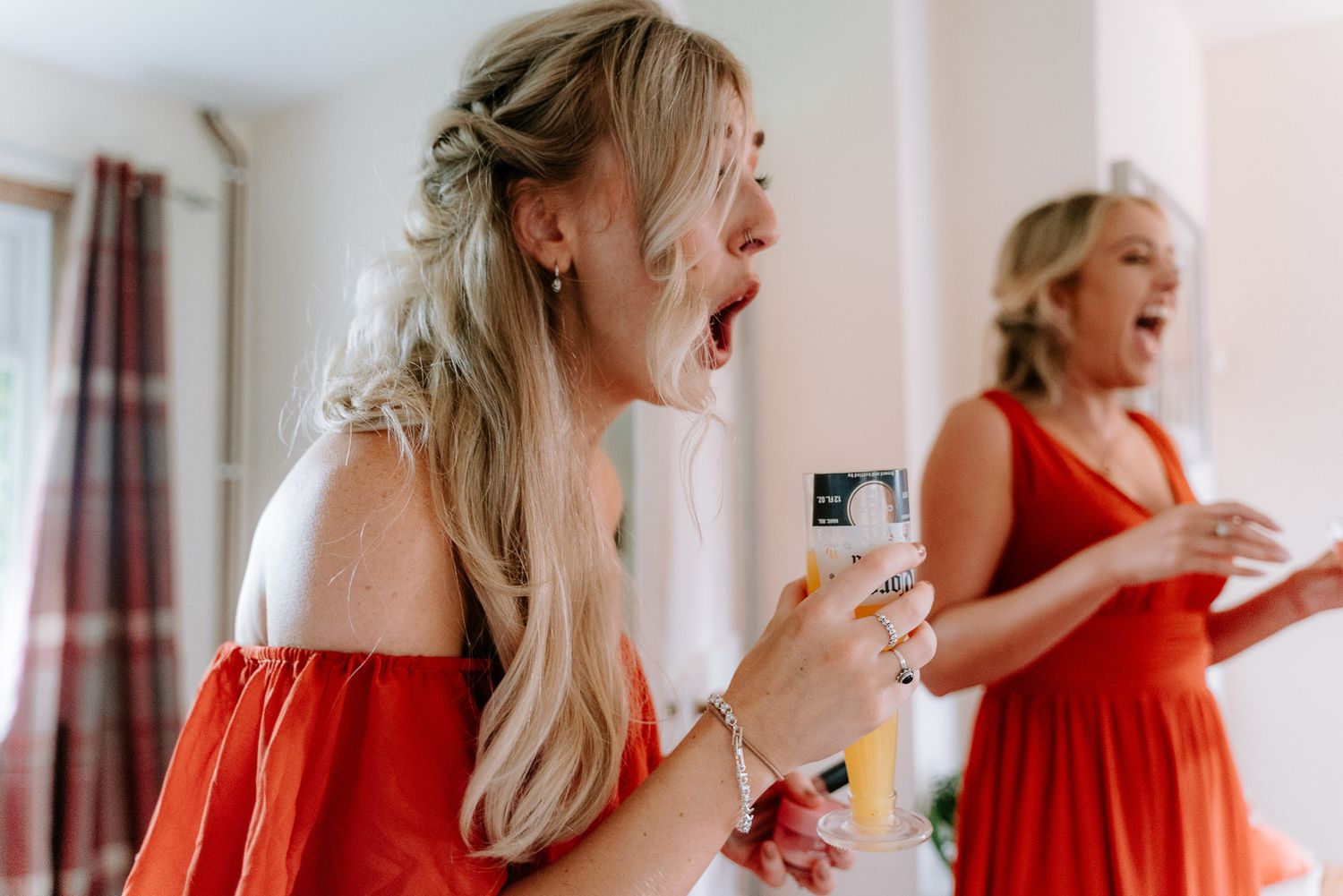 Women in red dresses react with excitement and joy during wedding preparations.