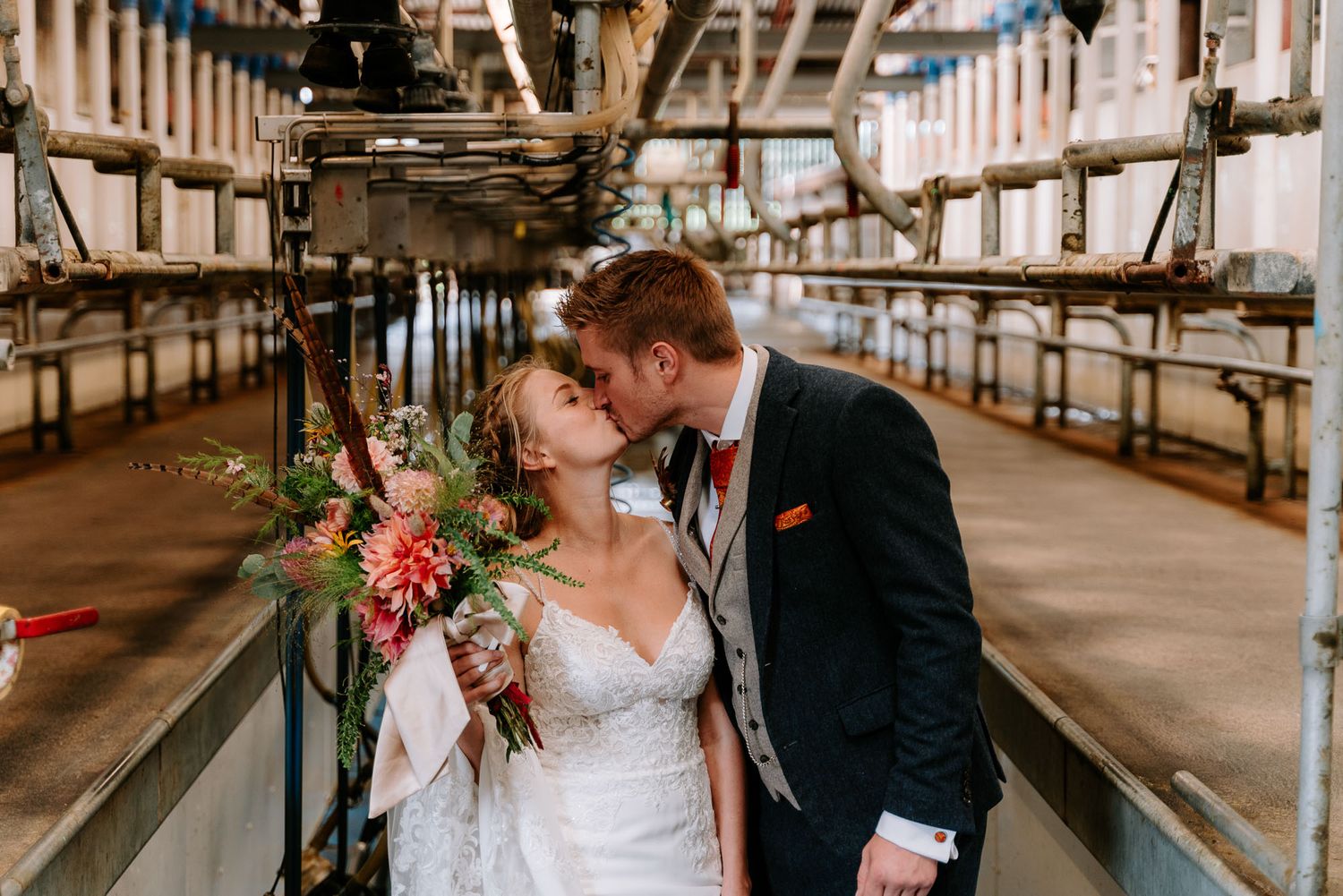 Newlyweds share intimate moments in an industrial warehouse setting.