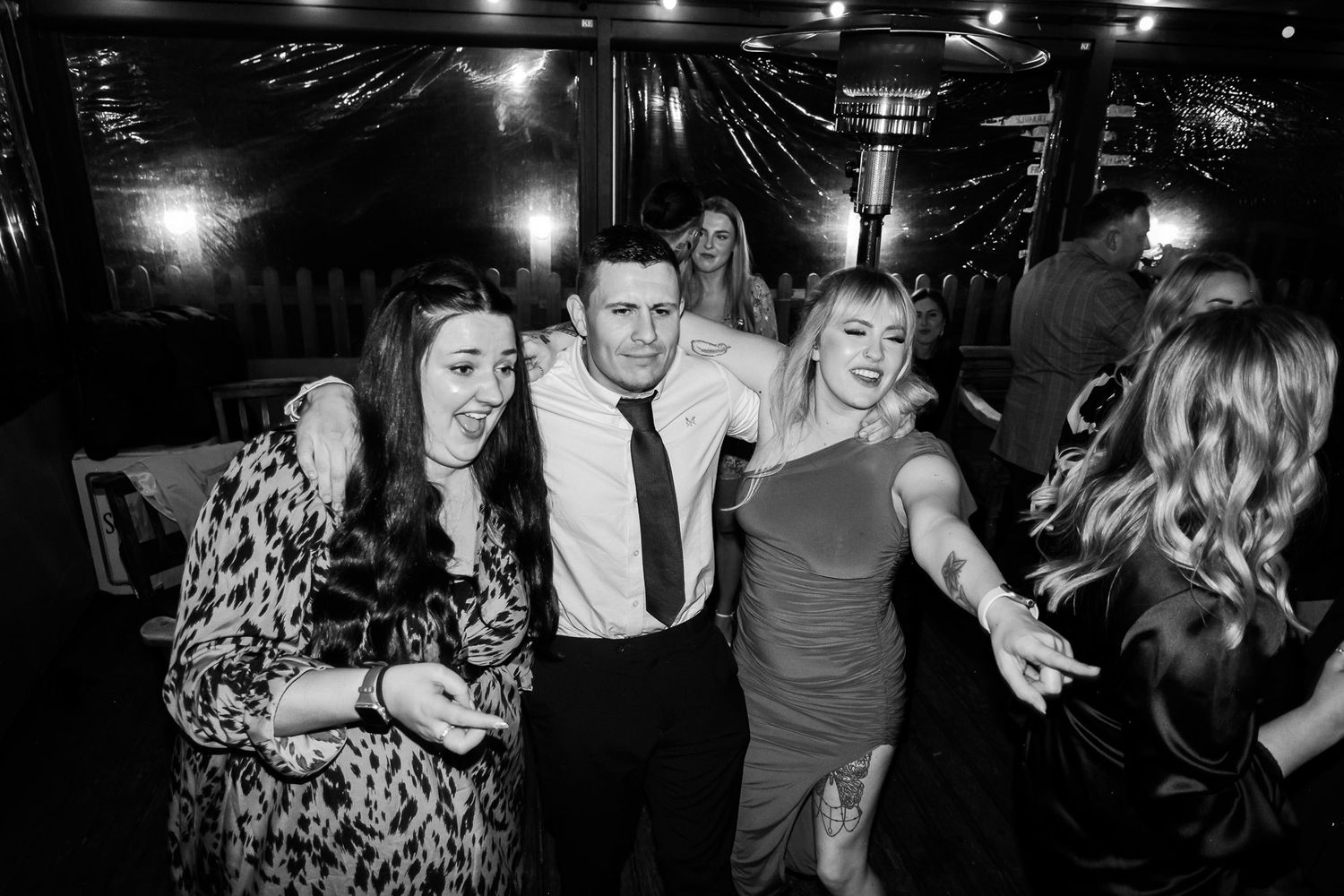 A lively dance party scene with people enjoying themselves in a dimly lit venue.