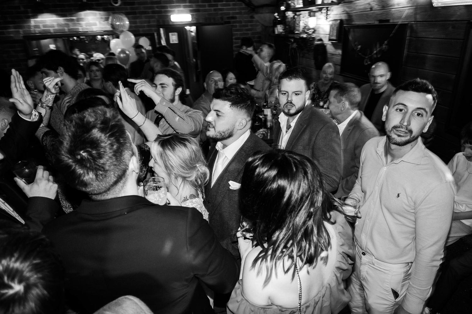 Crowded dance floor with people dancing and socializing at a nighttime event.