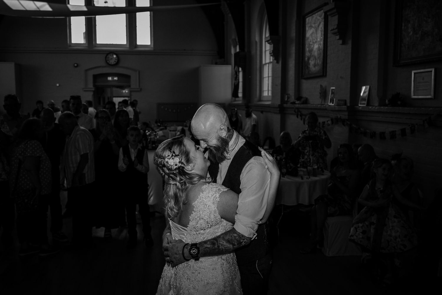Dark indoor venue with silhouettes of people dancing and celebrating.