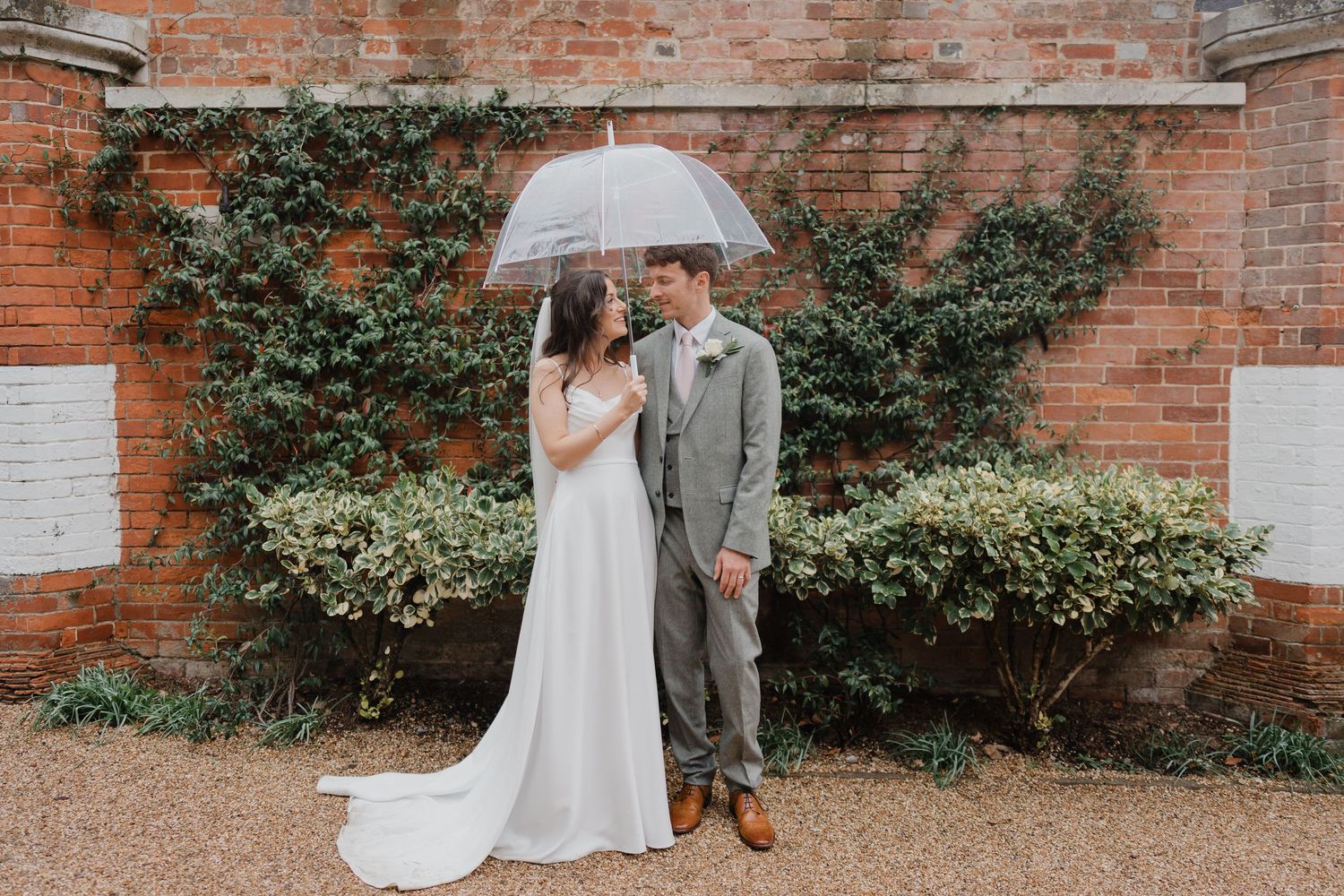 Wedding venue exterior features red brick walls and lush greenery.