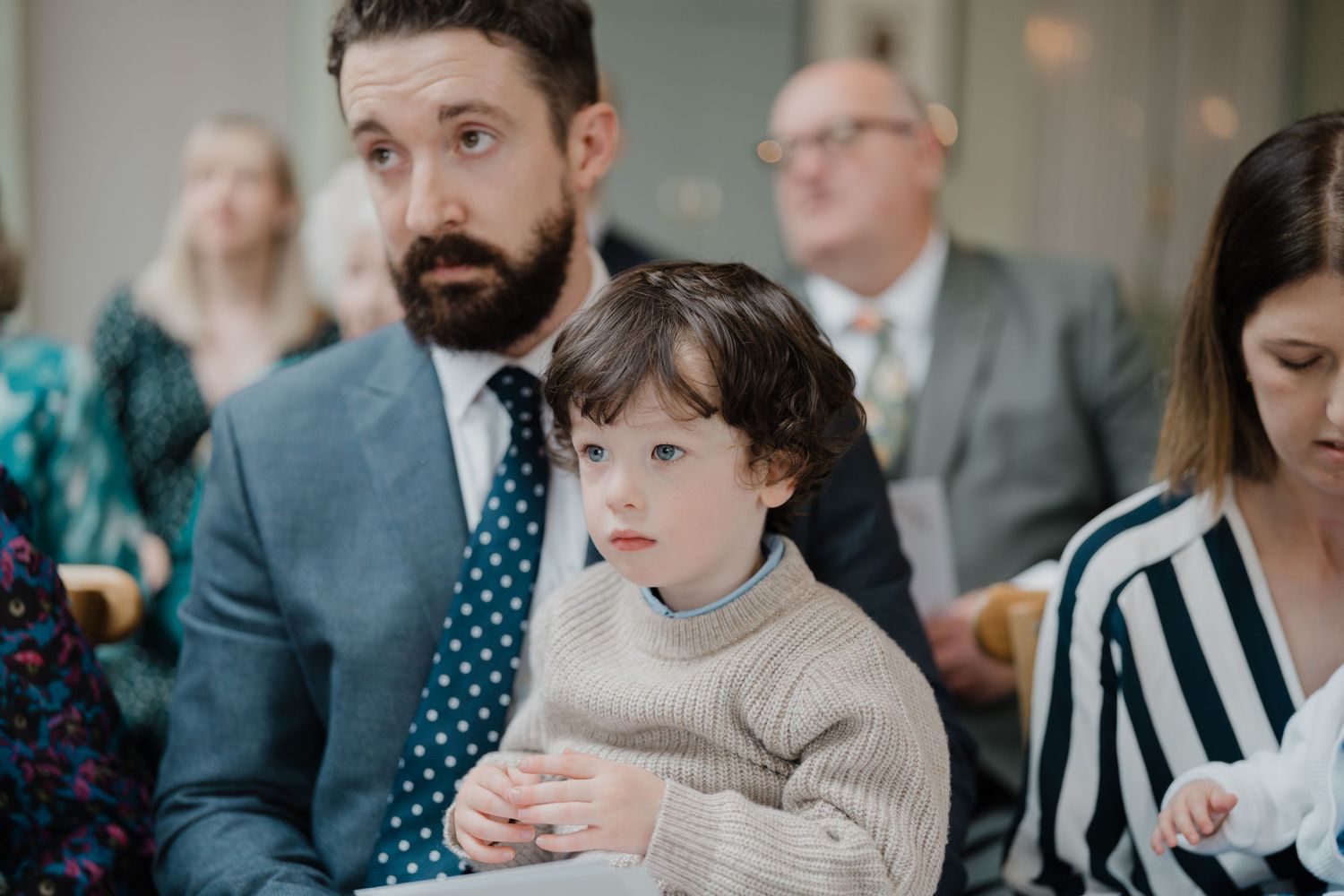 Wedding guests share conversations during an indoor reception event.