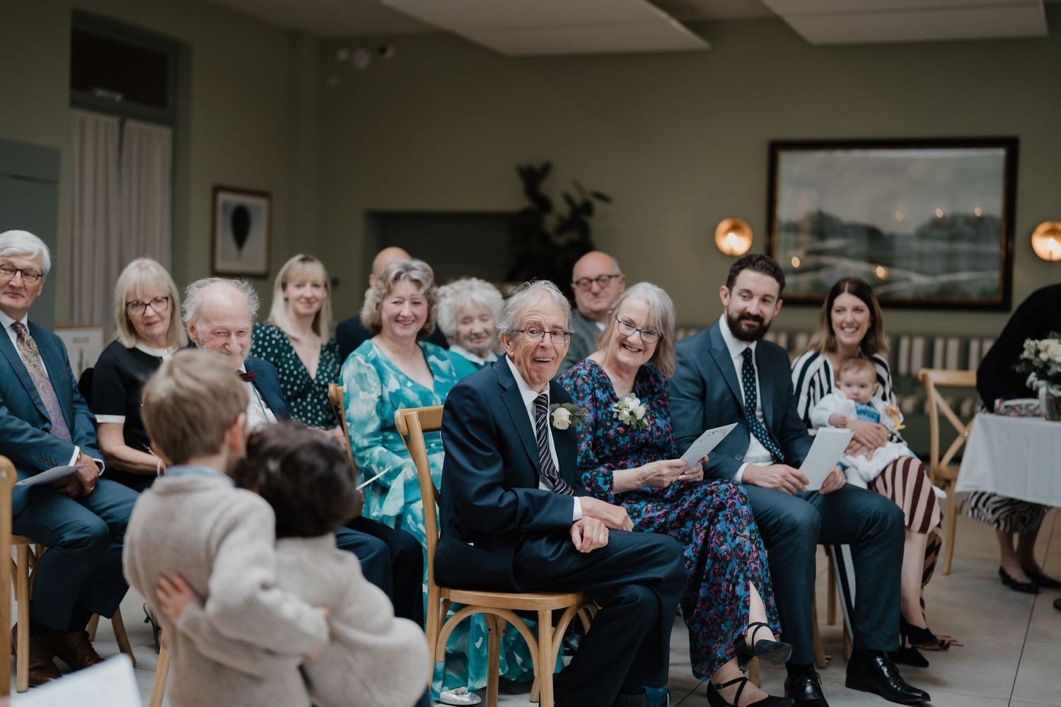 Guests seated in rows during a wedding ceremony in an elegant indoor venue.