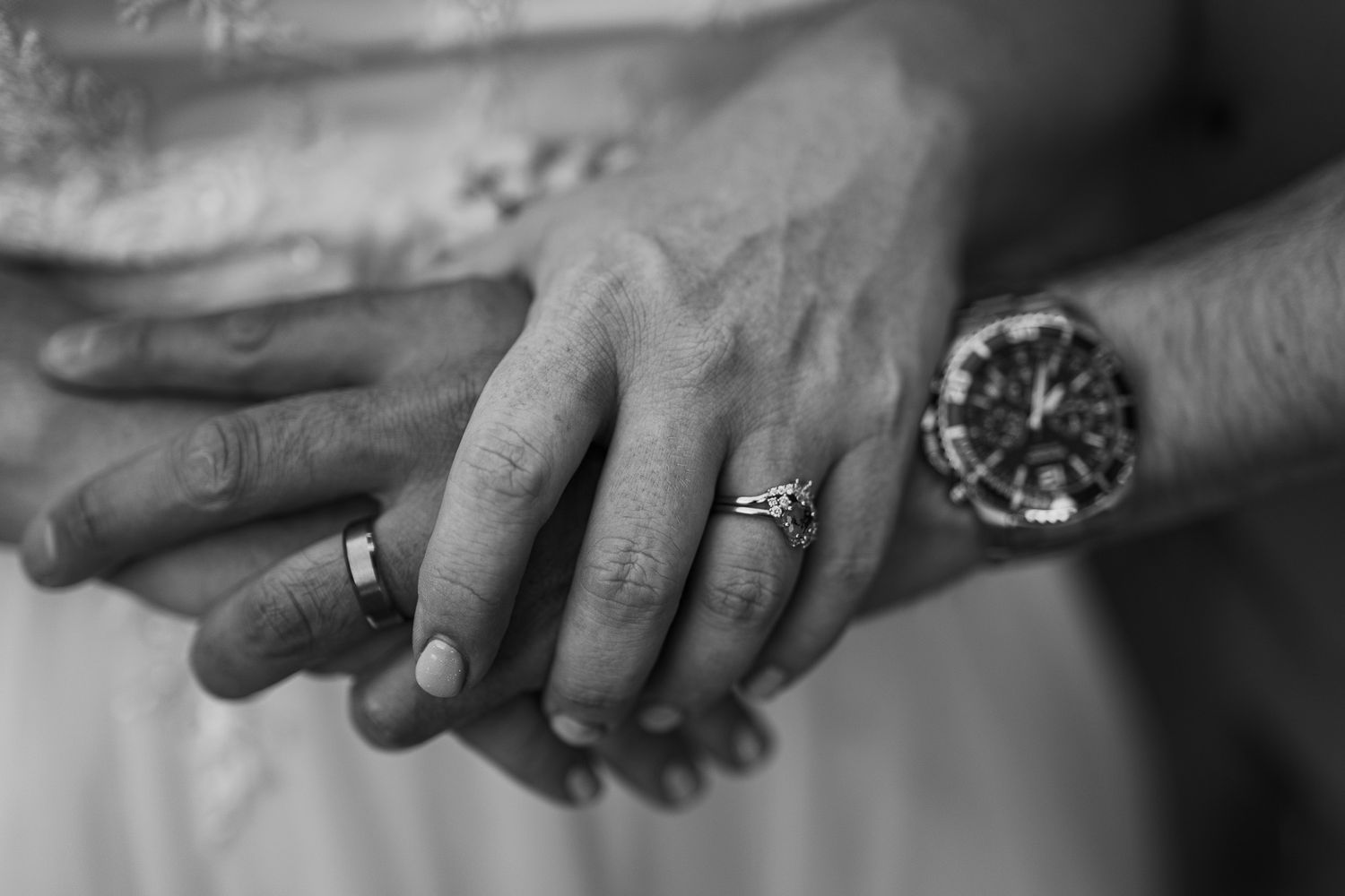 Close-up of hands with wedding rings being exchanged during a ceremony.