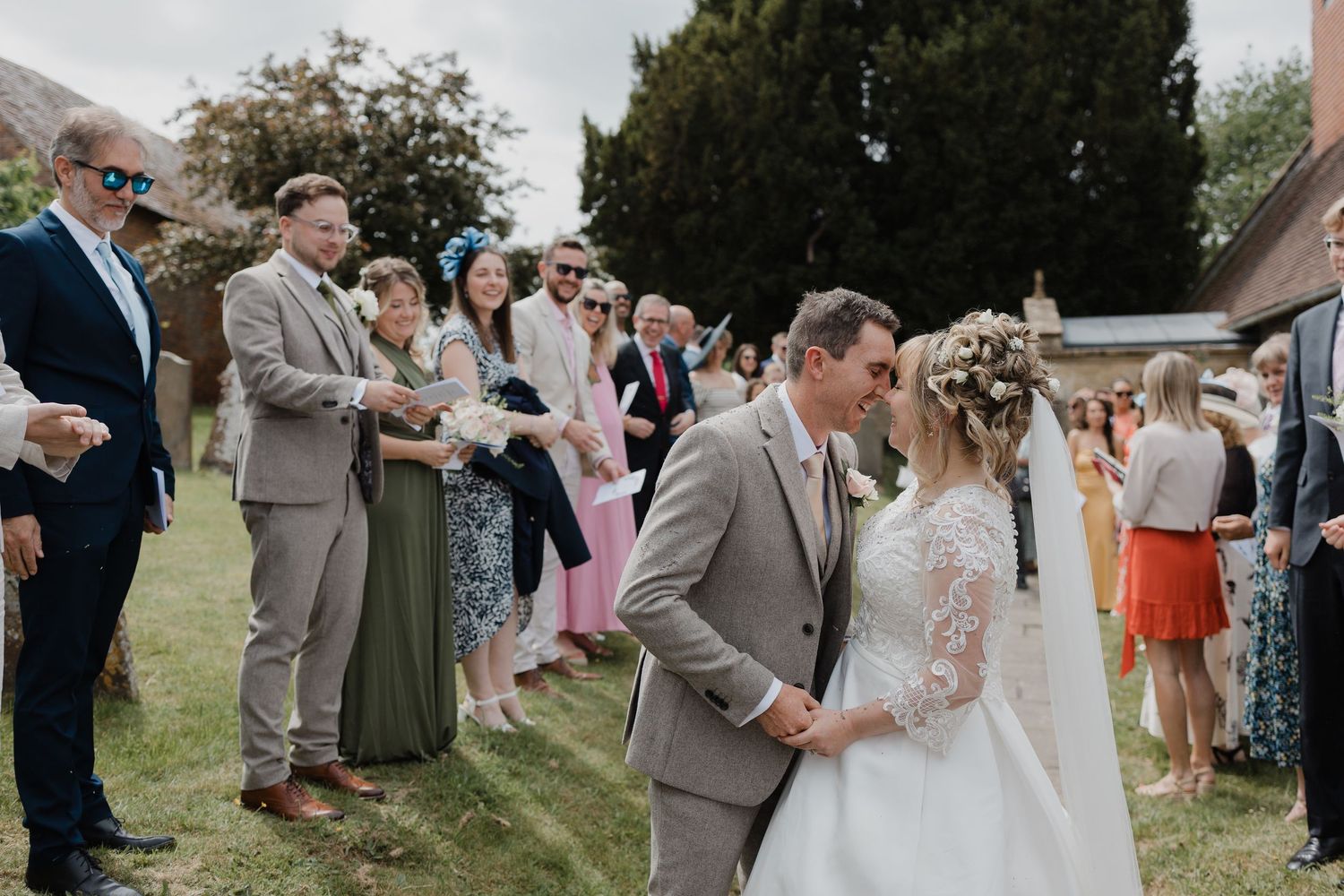 Wedding guests lined up outdoors celebrating with the newlyweds.