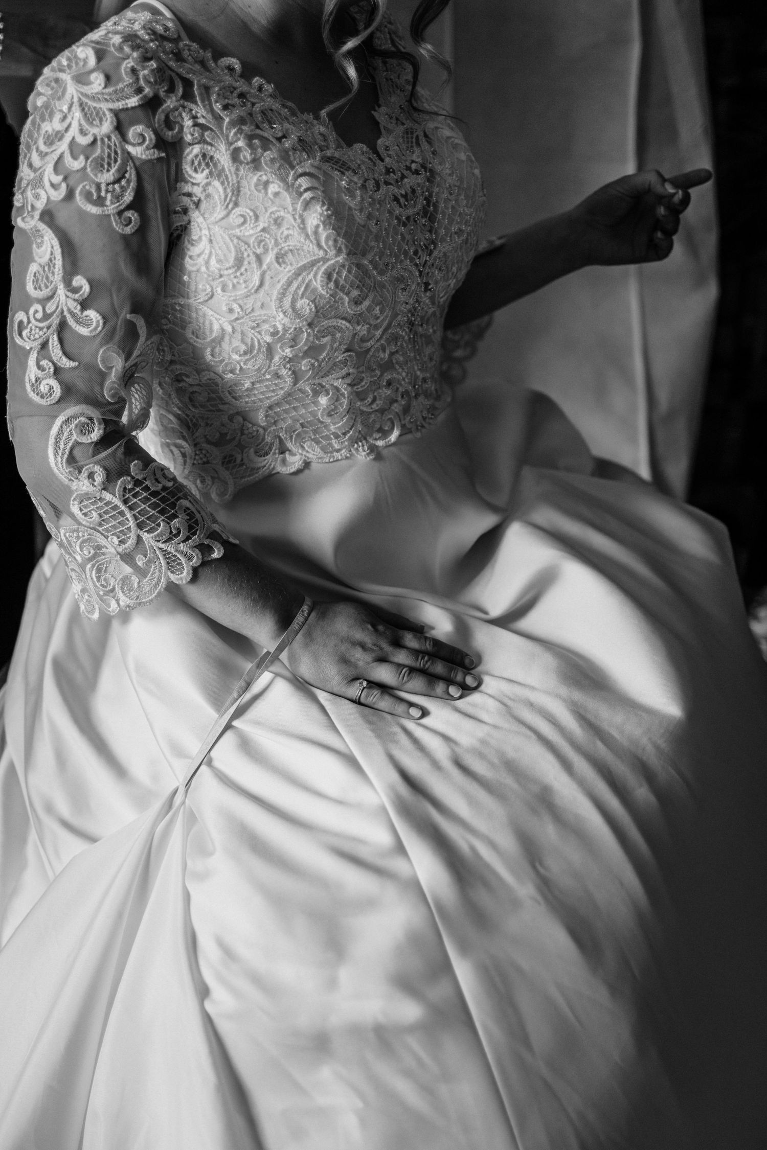 Close-up detail of intricate lace patterns on a white wedding dress.