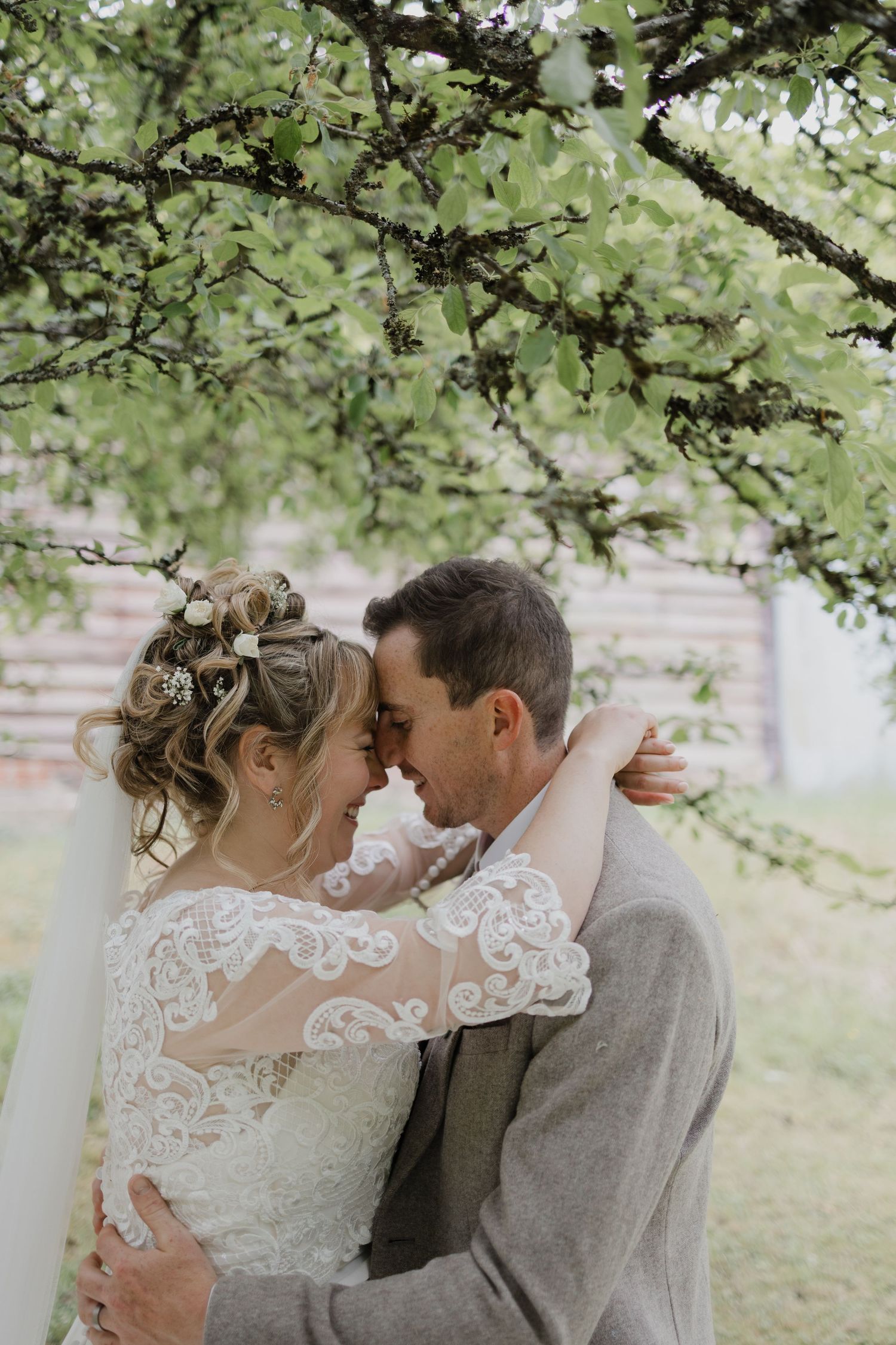 Romantic wedding portraits taken under blooming tree branches.